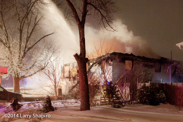 firemen battle house fire in snow storm at night