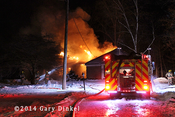 night photo of house fully engulfed in flames