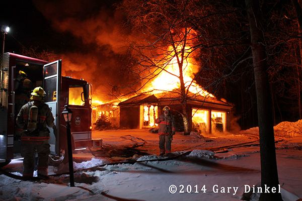 night photo of house fully engulfed in flames