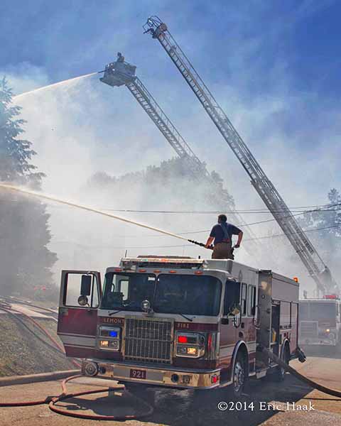fire engine and ladder trucks battle house fire