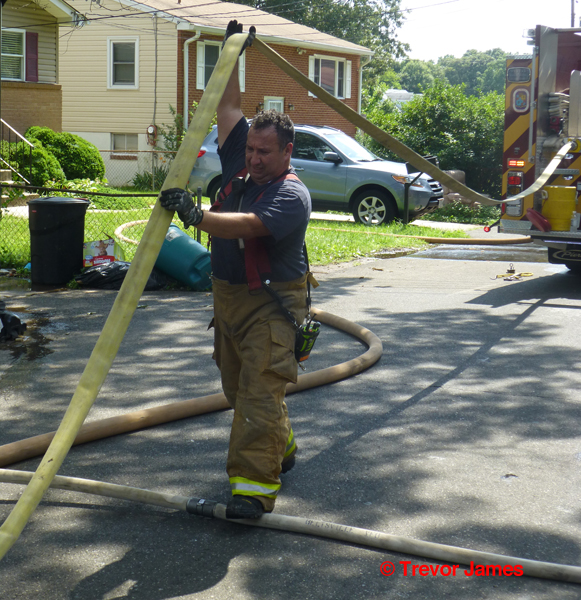 fireman rolls hose