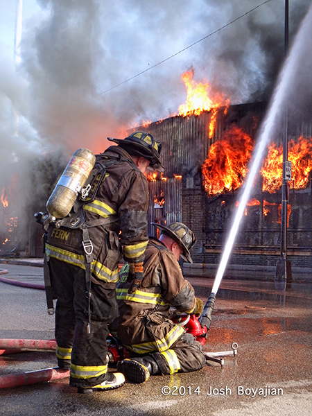 firefighters operate a multi-versal at a large fire