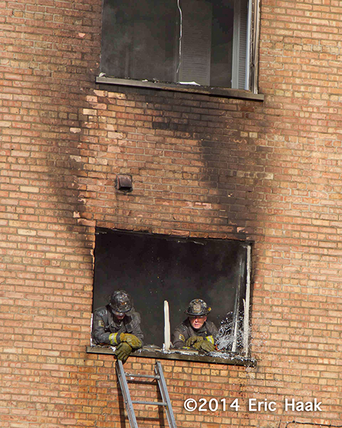 firemen rest after overhauling apartment fire