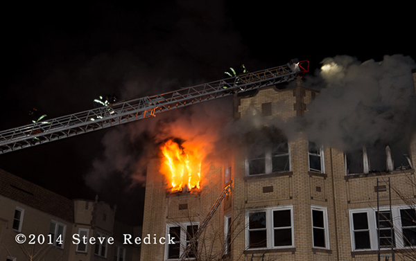 Chicago firefighters on aerial ladder with heavy fire and smoke