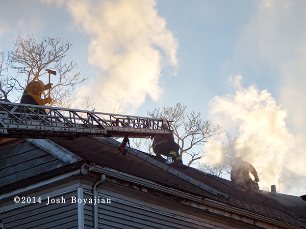 firemen on roof at house fire
