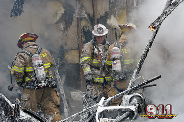 firemen use foam to fight a residential garage fire