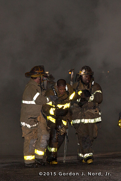 firemen help injured firefighter