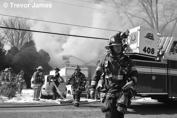 firefighters with fire truck at house fire