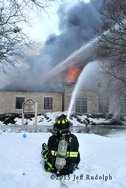 fireman with hose line at winter fire scene