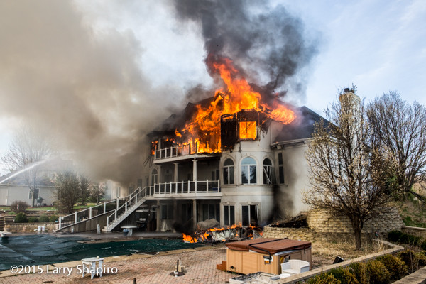 mansion on fire with heavy smoke and flames