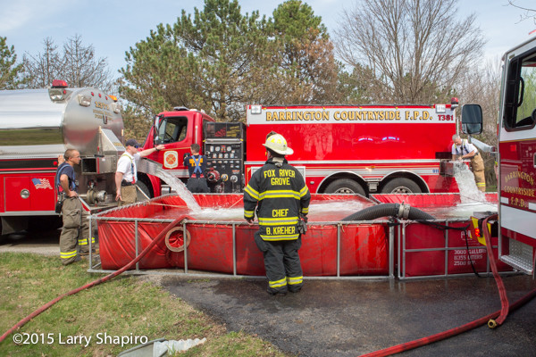 fire department water tenders dump into portable tanks