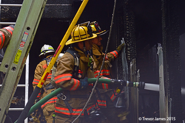 firemen overhaul fire scene and chase hot spots