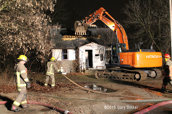 excavator tears down vacant house after fire