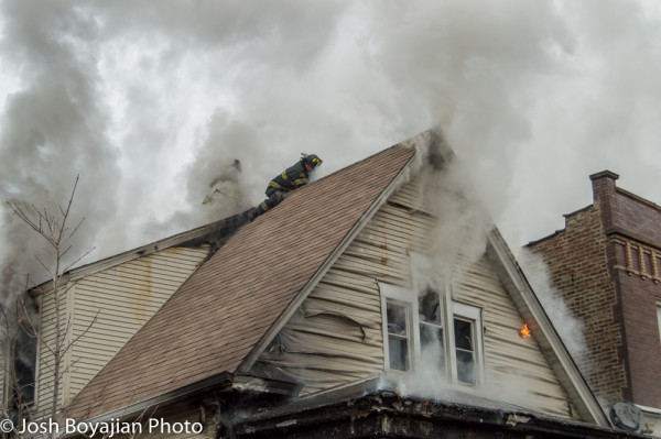 firemen on peaked roof during fire