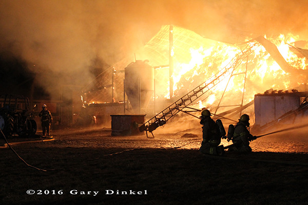 dairy barn fully engulfed in flames at night