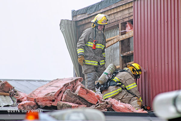 firemen overhaul roof after fire