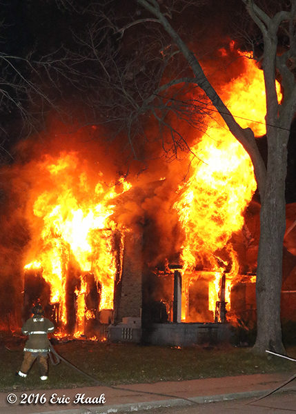 firefighter at fully engulfed house fire