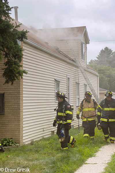 firefighters survey house fire