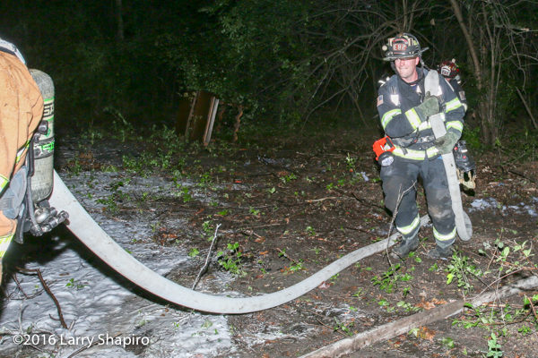 firefighters moving hose during a fire