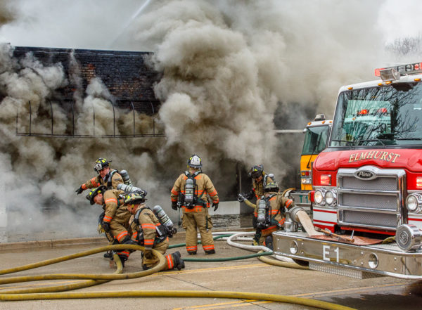firefighters battle fire with heavy smoke