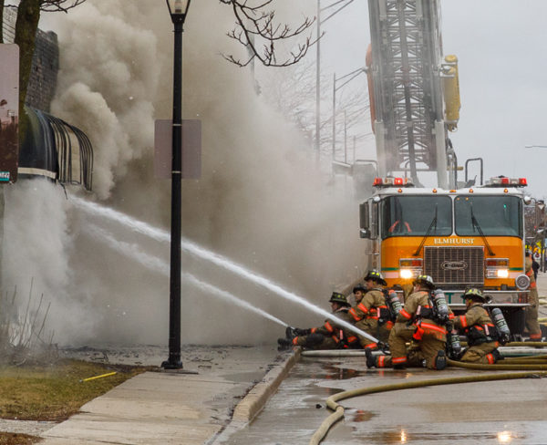 firefighters battle fire with heavy smoke