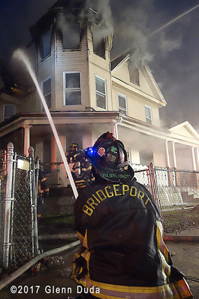 Bridgeport firefighter operating hose at fire scene