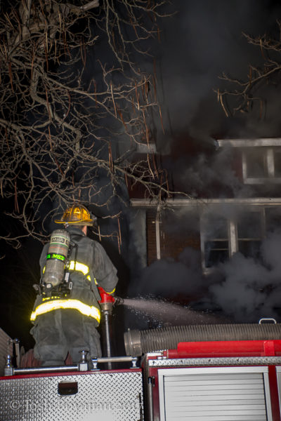 Detroit firefighter with hose at house fire