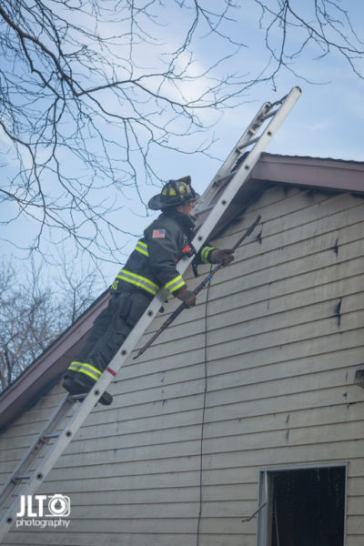 firefighter overhauls after house fire