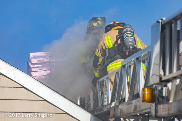 Firefighters on the tip[ of an aerial ladder