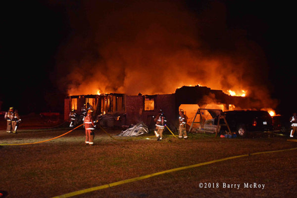 rural house engulfed in fire at night