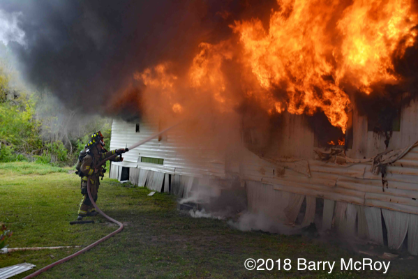 heavy smoke and flames from mobile home on fire