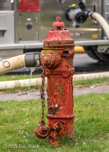 rusted fire hydrant with hose attached
