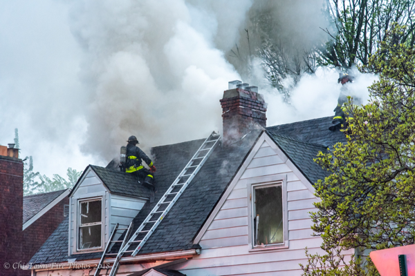 Firefighters vents roof during house fire with lots of smoke
