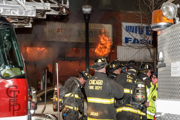 Chicago Firefighters battle a nighttime fire in a storefront