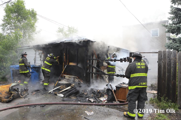 Firefighters overhaul after an alley garage burned in Chicago