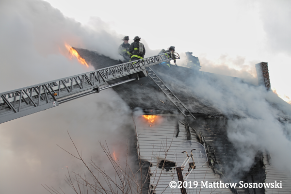 Detroit Firefighters venting peak roof during fire