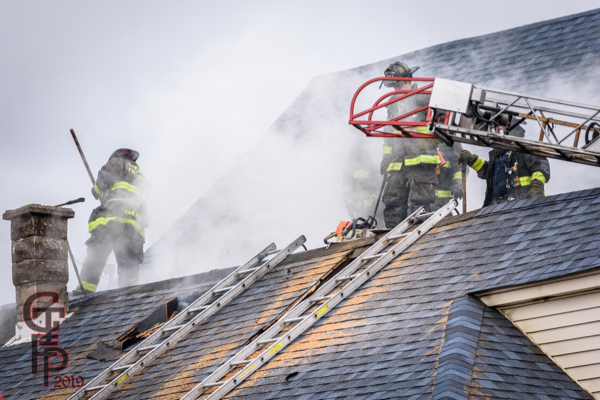 Firefighters vent roof of house on fire