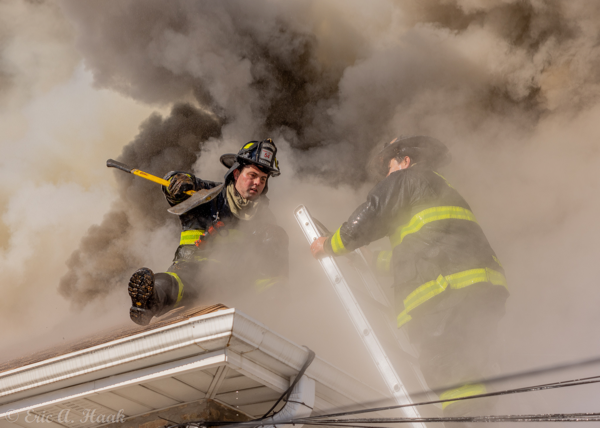 Firefighters on roof with heavy smoke