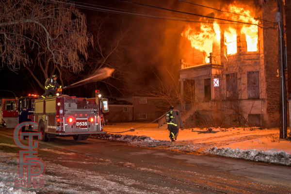 flames engulf vacant building at night